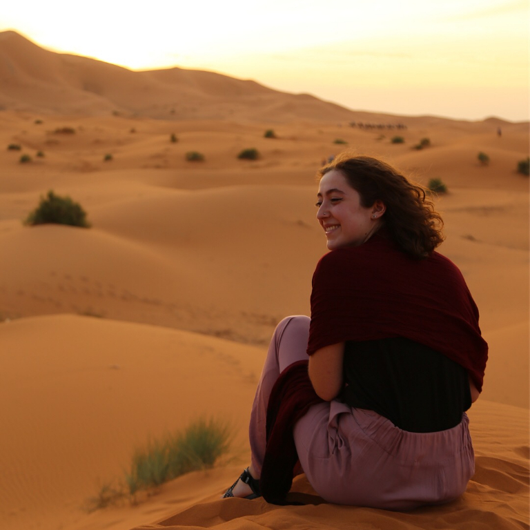 HIEP recipients in Africa - Ashley Cox sits on a sand dune in Morocco
