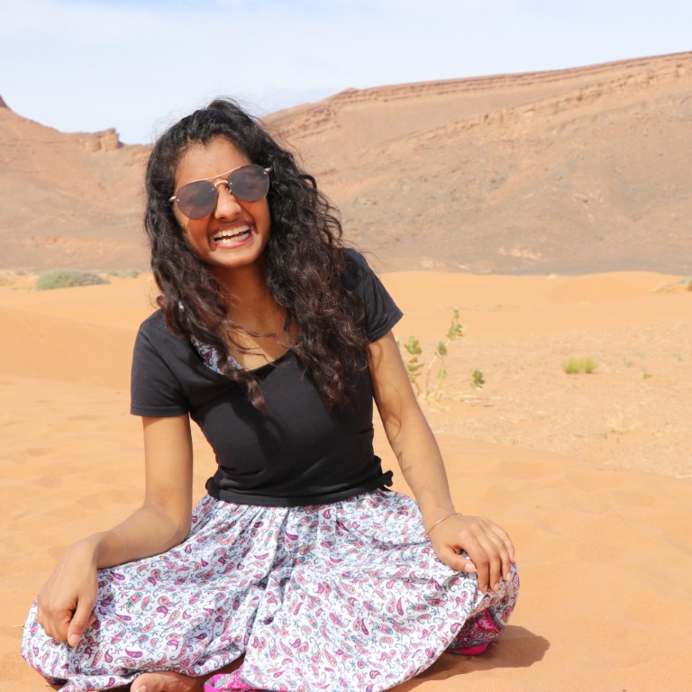 HIEP recipients in Africa - Nivedha Meyyappan sits in a dress on a sand dune in Morocco