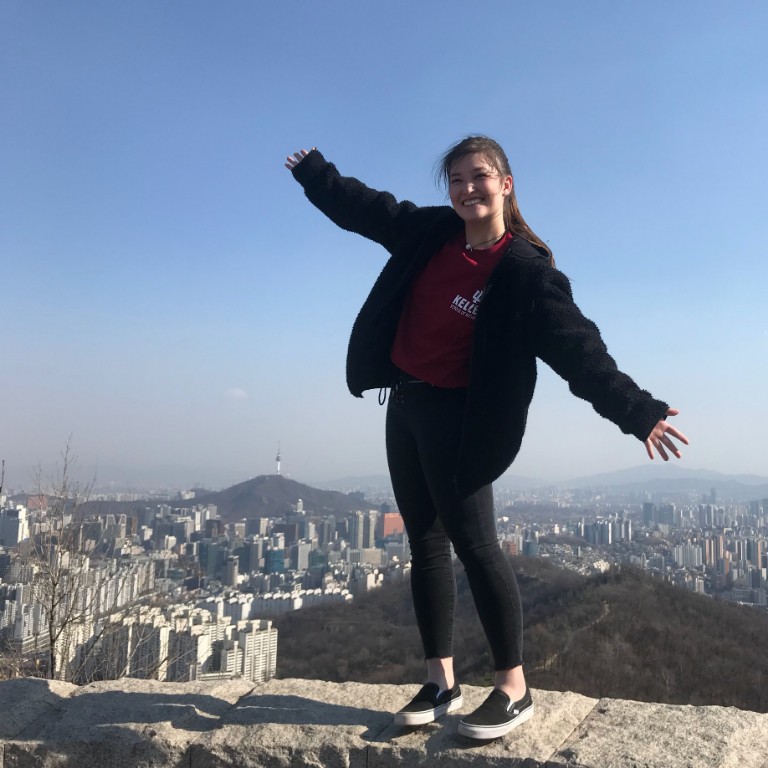 HIEP recipients in Asia and the Middle East - Maddison McConahay poses for a photo on a cliff overlooking a busy city in South Korea.