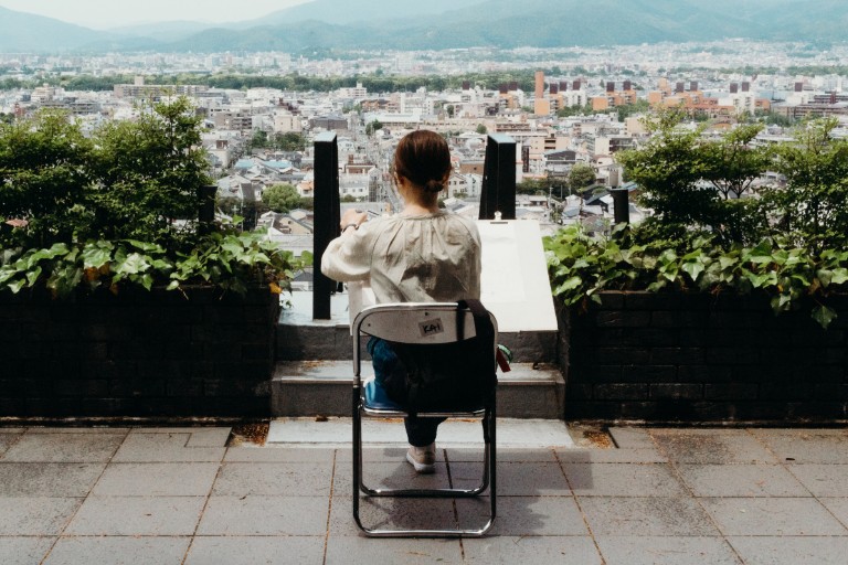 HIEP recipients in Asia and the Middle East - Photo by Kevin Phan - a woman draws on a large board while looking out over Kyoto.